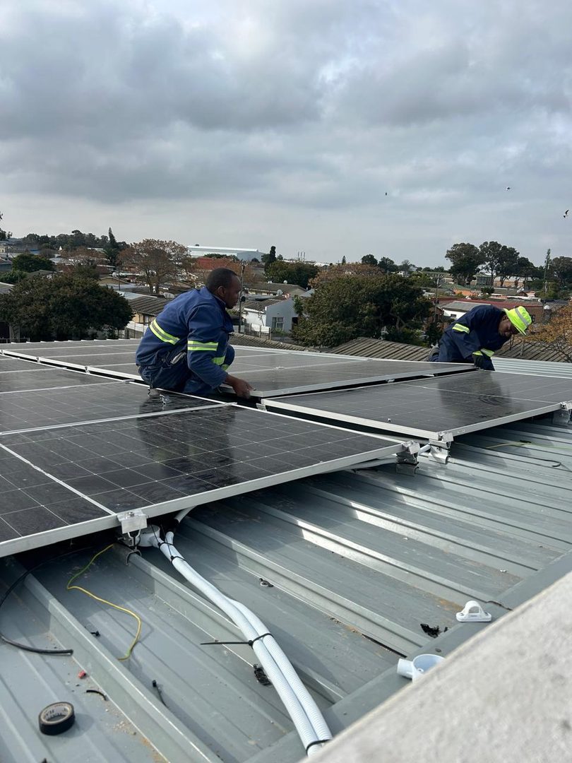 Technicians fitting solar panels