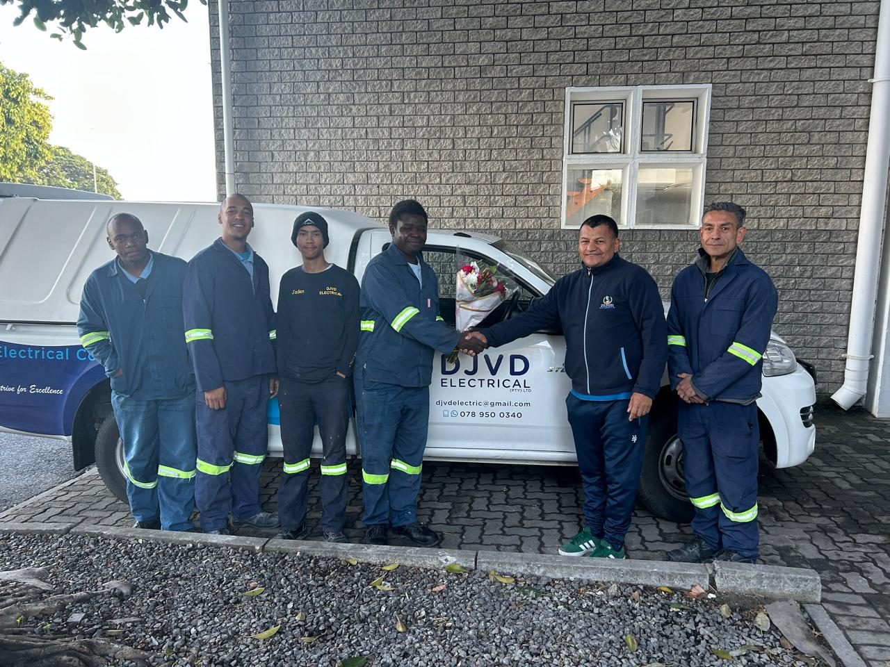 The DJVD Electrical family team beside their branded vehicle